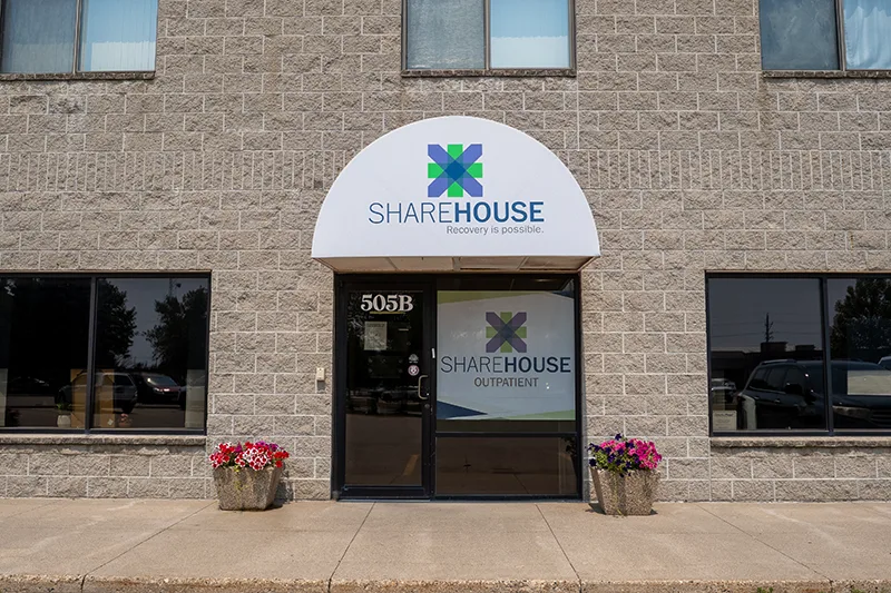 ShareHouse Outpatient front entrance, featuring exterior signage and potted flowers.